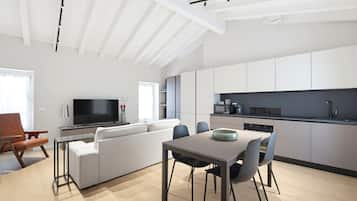 A modern living space with a dining area, kitchen, and seating.