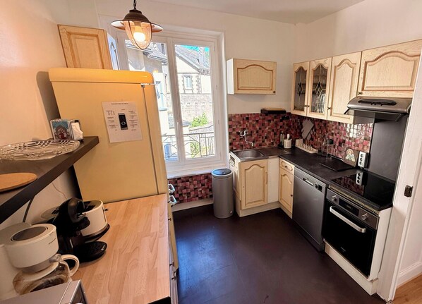 A compact kitchen with a refrigerator, sink, stove, and a window with a view of the outside. - Le Goupil, Le Mont Dore (sleeps 6) (Mont-Dore)
