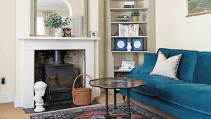 Ein Wohnzimmer mit Kamin, einer Couch, einem Couchtisch und einem Bücherregal.