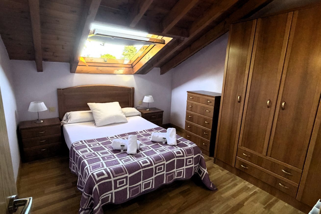 A bedroom with a bed, nightstands, a dresser, and a wardrobe.
