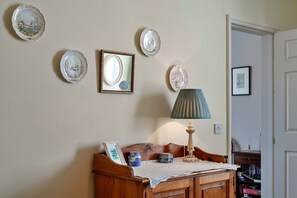 Ein Zimmer mit einer hölzernen Bank, einer Lampe und dekorativen Tellern an der Wand.