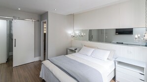 A modern bedroom with a bed, bedside tables, a wardrobe, and a large mirror. - Copacabana River (Rio de Janeiro)