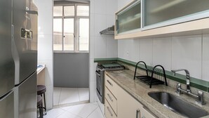 A kitchen with a refrigerator, stove, sink, and window. - Copacabana River (Rio de Janeiro)