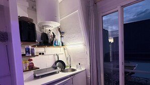 Una cucina compatta con lavello, fornelli e diversi utensili.