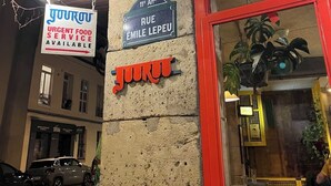 Un edificio con un cartello che indica 'JOUROU URGENT FOOD SERVICE AVAILABLE' e 'RUE EMILE LEPEU'.