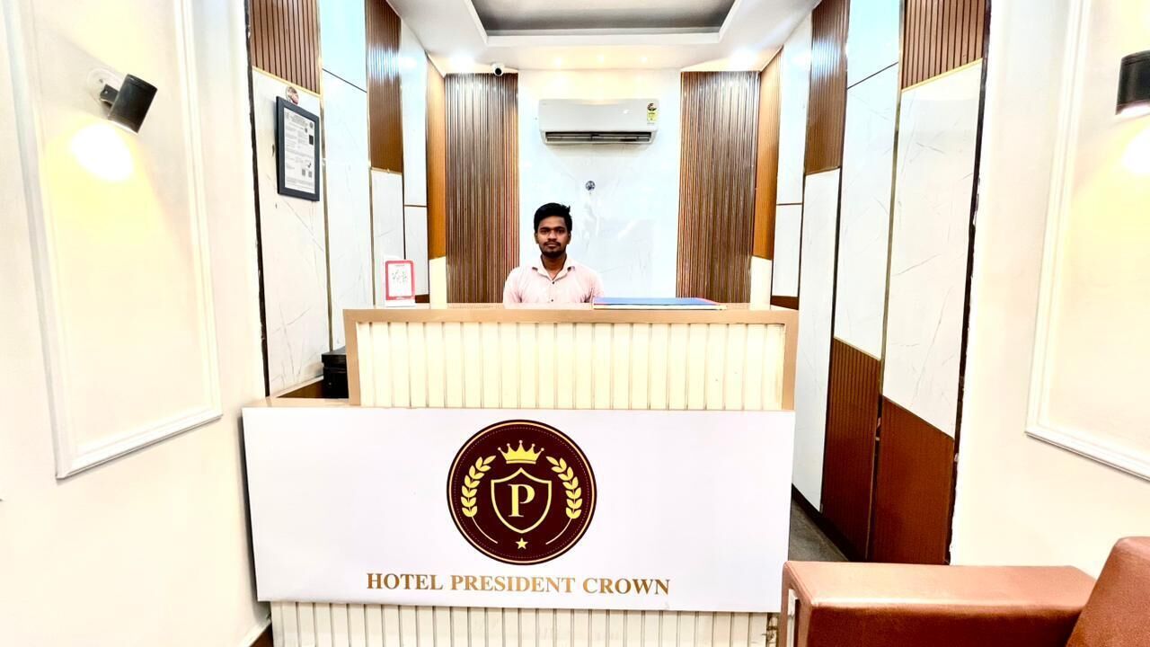 A hotel reception desk with a sign reading 'HOTEL PRESIDENT CROWN.'