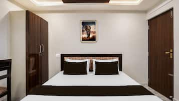 Un dormitorio con cama, dos mesitas de noche, cabecera, armario y un cuadro en la pared.