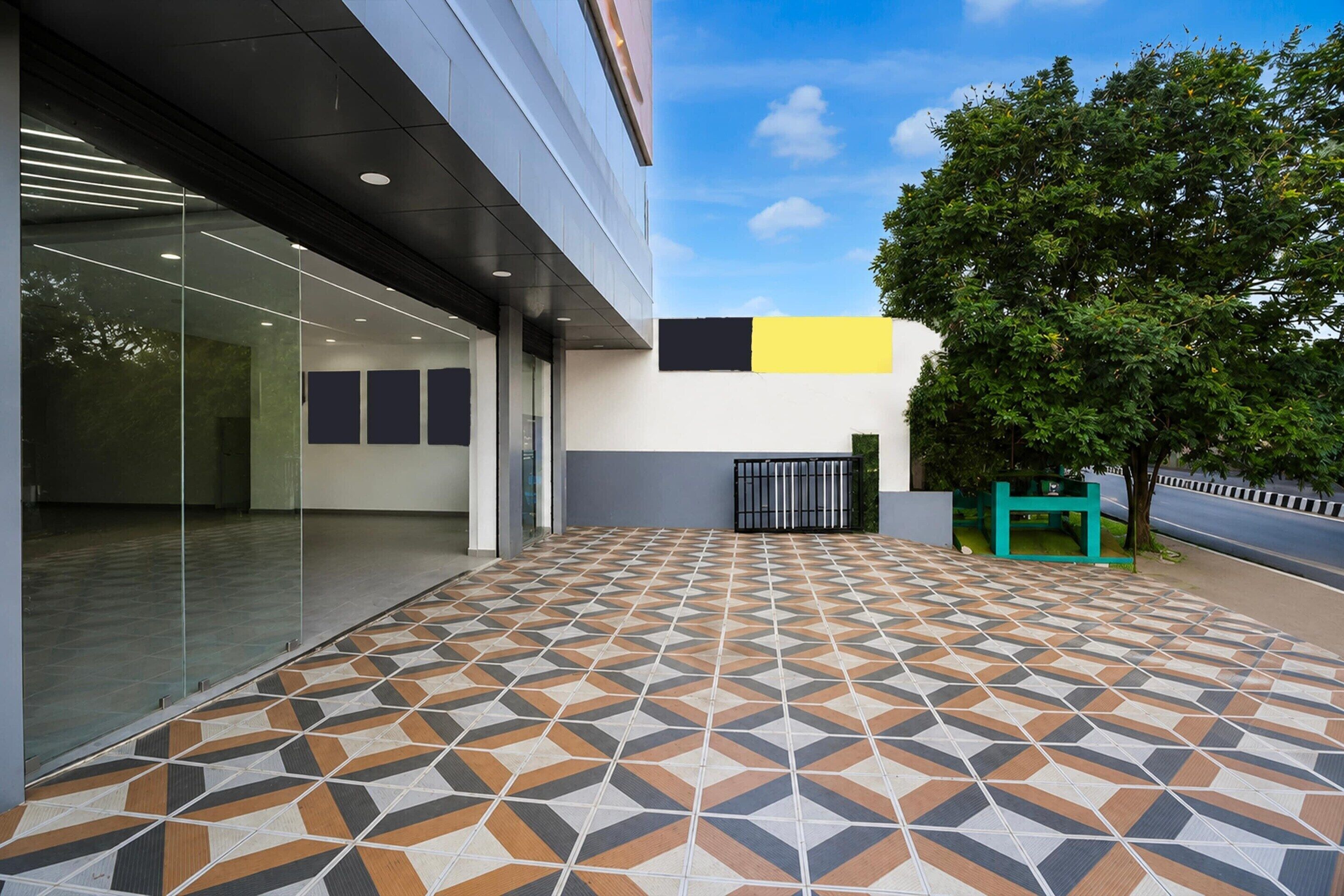 Un bâtiment moderne avec une façade contemporaine, un sol carrelé à motifs, des murs en verre et un arbre.