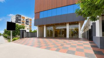 A modern building with a checkered entrance, glass doors, and a visible reception area.