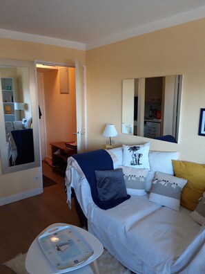 Une chambre d’hôtel comprenant un lit, une table de chevet, un miroir et une armoire.