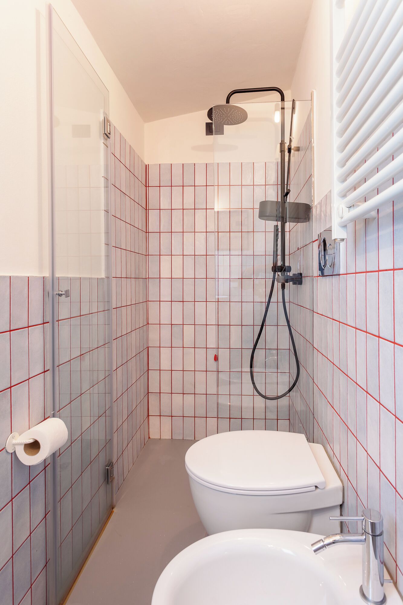 Un baño pequeño con inodoro, lavamanos y ducha.