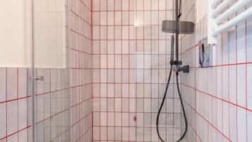 Un baño pequeño con inodoro, lavamanos y ducha.