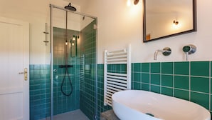A bathroom with a glass-enclosed shower, a white sink, and green tiled walls. - A Casa Da Angelo - Country House (Grottammare)