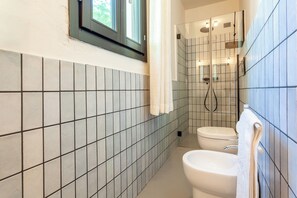 Habitación doble, vista al patio | Baño | Regadera, regadera tipo lluvia, secadora de cabello, pantuflas 