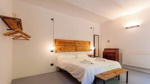 A bedroom with a bed, bedside table, wooden headboard, and a radiator. - A Casa Da Angelo - Country House (Grottammare)