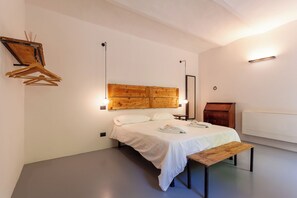 A bedroom with a bed, bedside table, wooden headboard, and a radiator. - A Casa Da Angelo - Country House (Grottammare)