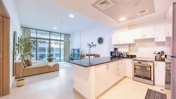 Una cocina moderna con armarios blancos, una isla central y un horno empotrado.