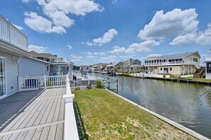 A waterfront property with a wooden deck, a dock, and a canal. - Newly Renovated 4-Bedroom, 1.5-Bathroom Canal-Front Home in South Bethany Beach; Parking Pass, Free WIFI and 2 Large Decks! (Bethany Beach)