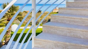 Un escalier avec des rampes blanches menant à un point de vue sur la mer.