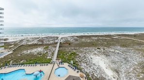 A beach resort with a pool area, a boardwalk, and a view of the beach. - Phoenix VIII by Brett Robins Vacations (Orange Beach)