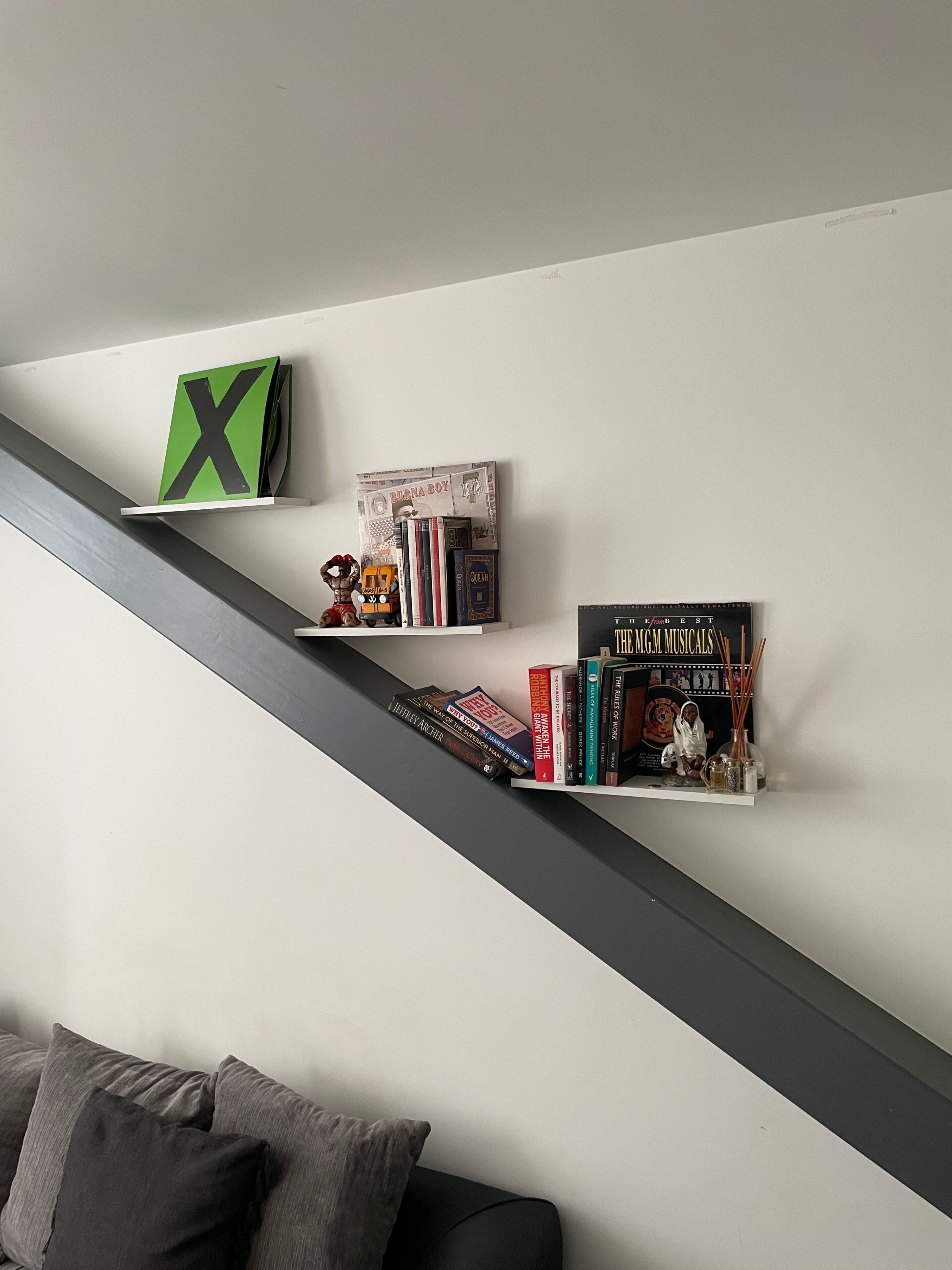 A bookshelf with books and decorative items, a letter X, and a small toy train.
