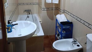 Une salle de bain avec une baignoire, un lavabo, des toilettes et une douche.