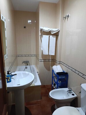 Ein Badezimmer mit einer Badewanne, einem Waschbecken, einer Toilette und einer Dusche.