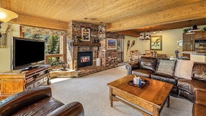 A cozy living room with a fireplace, leather furniture, and a television. - Slope-Side Retreat at the Steamboat Resort Base Area (Steamboat Springs)