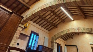 Een kamer met houten balken, een bakstenen boog en een radiator.