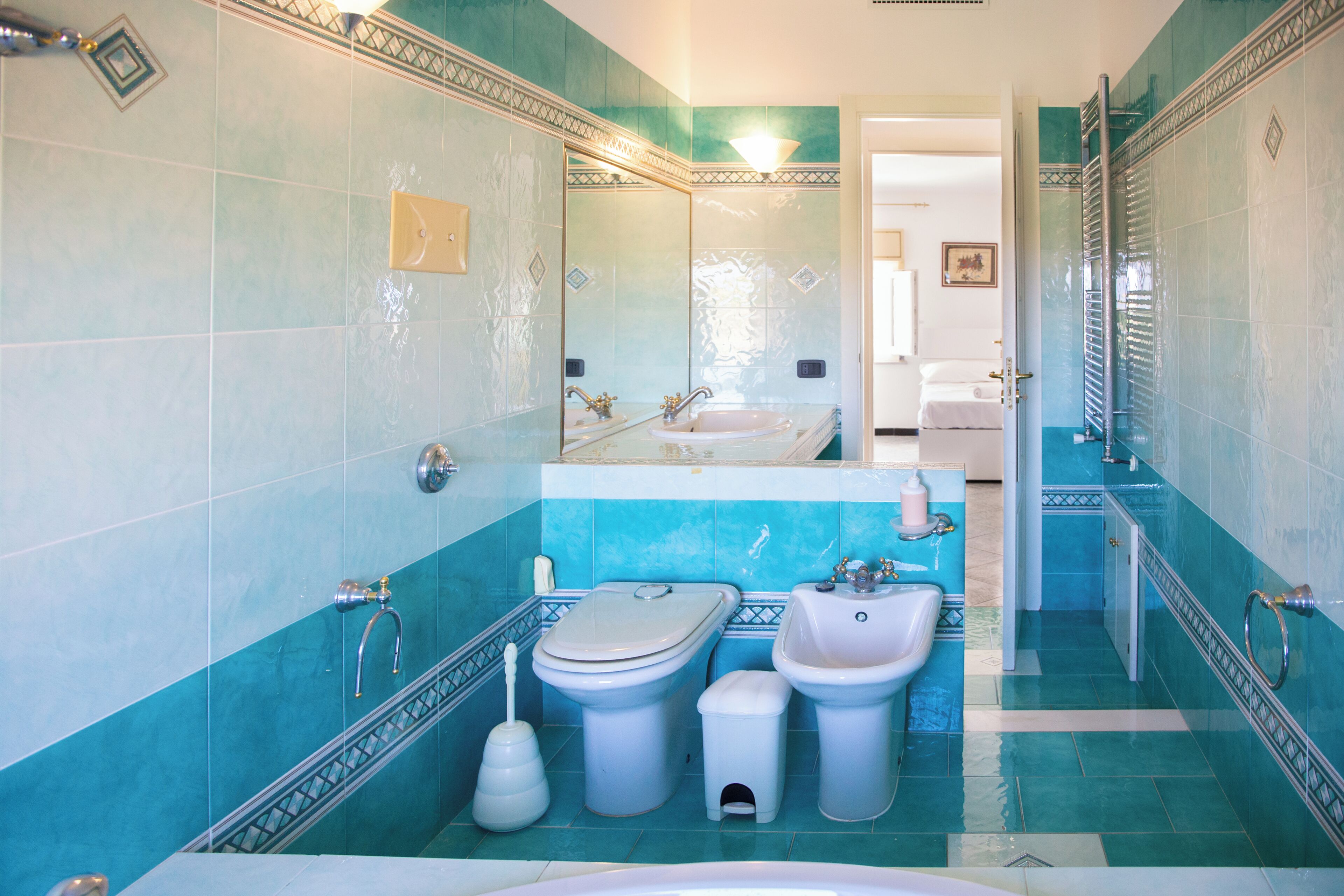 A bathroom with a toilet, bidet, sink, and bathtub.