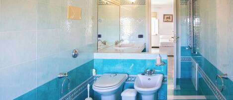 A bathroom with a toilet, bidet, sink, and bathtub.