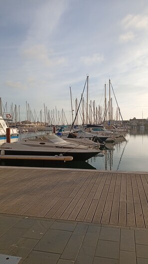 A marina with multiple boats docked, a wooden deck, and calm water. - "Casa Del Mar" apartment, 28 m², sleeps 4, on the harbor, behind 5grand (Agde)