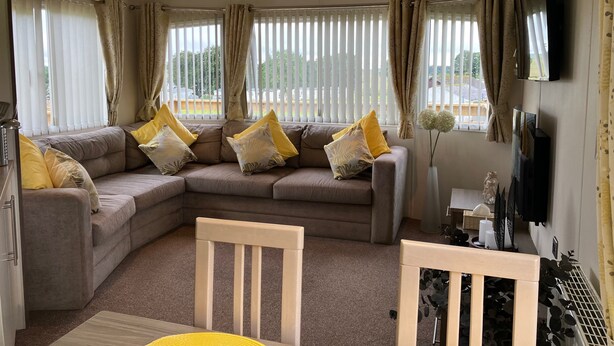 A living room with a sectional sofa, a TV, and a view of the outdoors. - Sleeps4-familyfriendly-greatamenities-freeparking (Newton Stewart)