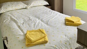 A bedroom with a bed, pillows, a headboard, a window, and a wooden wardrobe. - Sleeps4-familyfriendly-greatamenities-freeparking (Newton Stewart)
