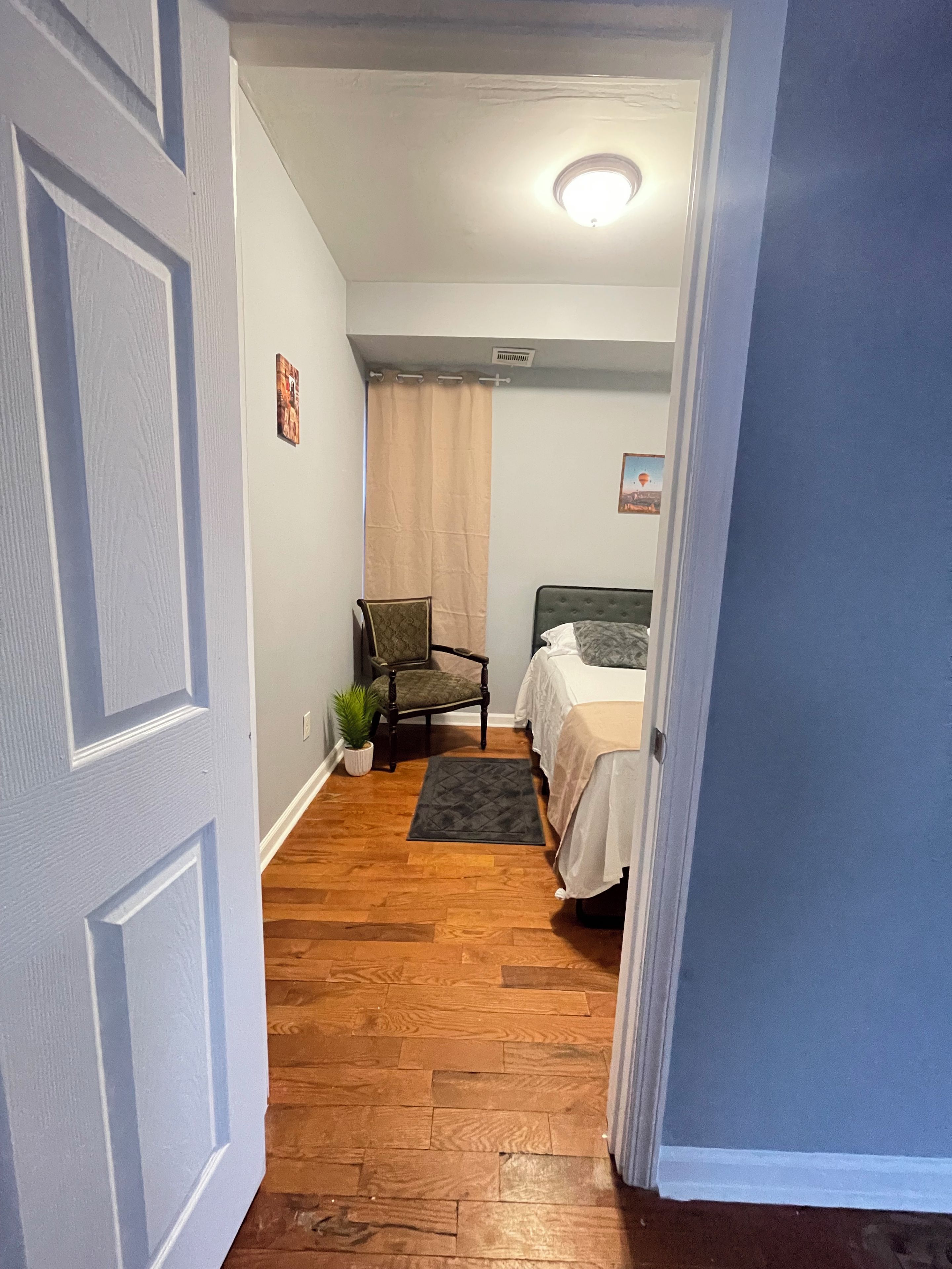 Une chambre à coucher avec un lit, une chaise et un petit tapis.