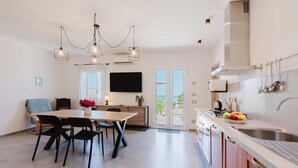 Een moderne keuken met een eethoek, een groot raam en een flatscreen-televisie.