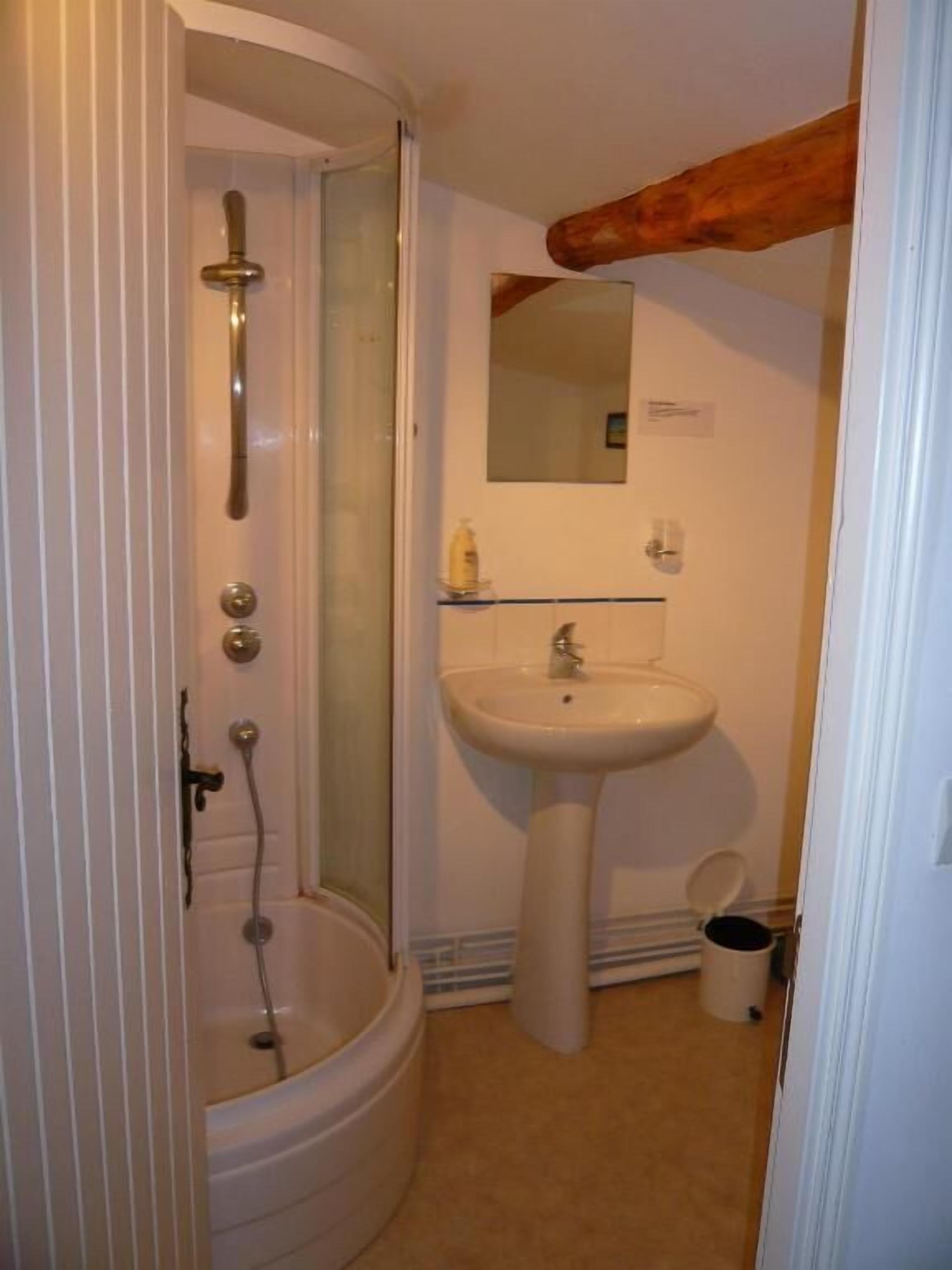 Un bagno con doccia, lavandino e specchio.