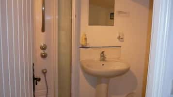 Un bagno con doccia, lavandino e specchio.