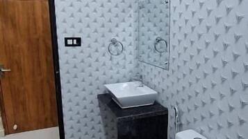 A bathroom with a toilet, sink, and mirror.