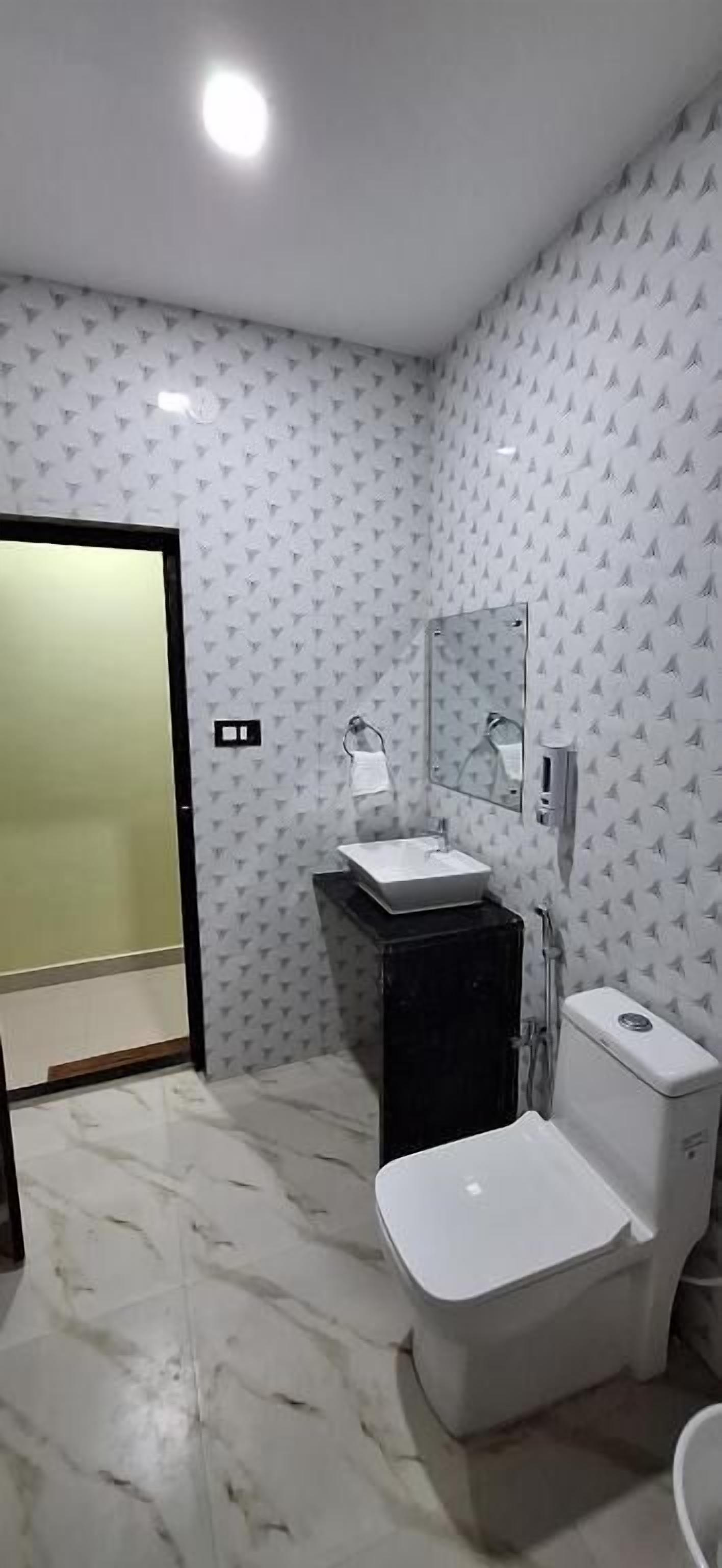 Baño con inodoro, lavabo y espejo.
