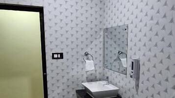 Baño con inodoro, lavabo y espejo.