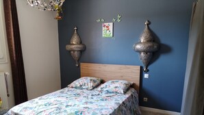 A bedroom with a wooden bed, floral bedding, two wall-mounted lamps, and a small artwork on the wall. - 8-sleeper country house, 50 minutes from the 24 Hours of Le Mans race track (Saint-Longis)