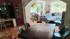 A dining area with a wooden table and chairs, a kitchen with a built-in oven, and a living area with a sofa and a TV. - 8-sleeper country house, 50 minutes from the 24 Hours of Le Mans race track (Saint-Longis)