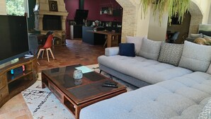 A living room with a sofa, a coffee table, a TV, and a fireplace. - 8-sleeper country house, 50 minutes from the 24 Hours of Le Mans race track (Saint-Longis)