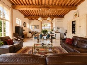 A spacious living area with leather sofas, a glass coffee table, and a wooden ceiling. - A place to recharge your batteries at the foot of the Pyrenees (Meillon)