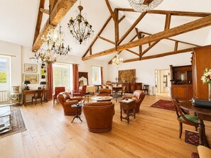 A spacious room with wooden beams, leather furniture, and chandeliers. - A place to recharge your batteries at the foot of the Pyrenees (Meillon)