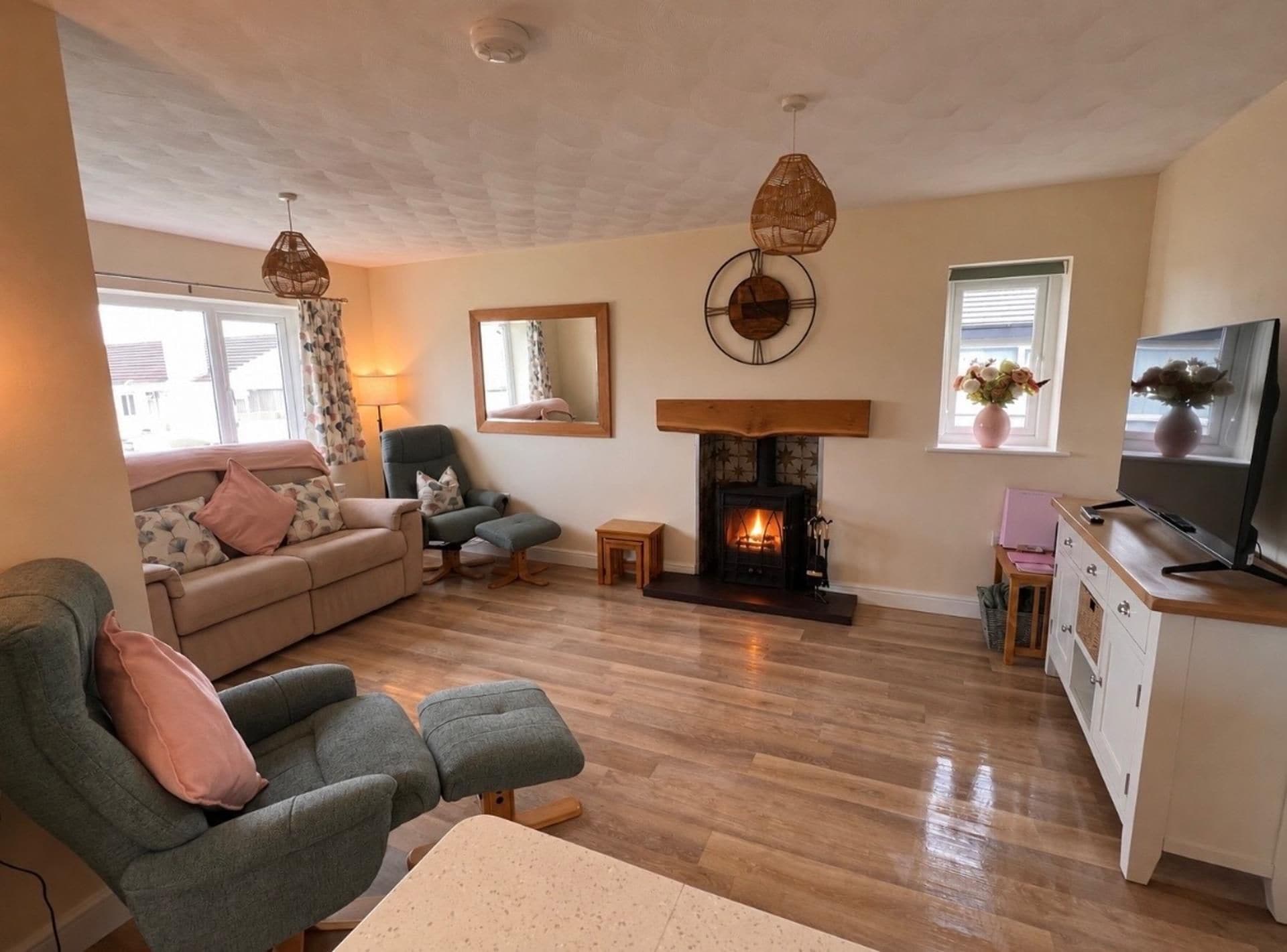 A living room with a fireplace, a sofa, a chair, and a television.