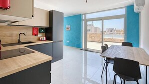 Una cocina moderna con fregadero, estufa y comedor con mesa y sillas.