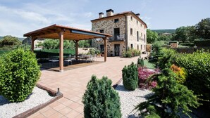 A stone building with a covered patio area and outdoor seating. - Room-rural House Santervas de la Sierra (Garray)