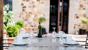 A table set for dining outdoors with a stone wall backdrop. - Room-rural House Santervas de la Sierra (Garray)